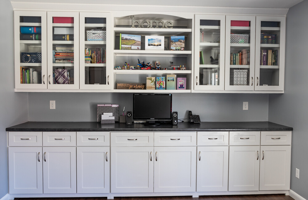 office builtin cabinets with long countertop and transparent storage in upper cabinets; versatile for office or dining storage
