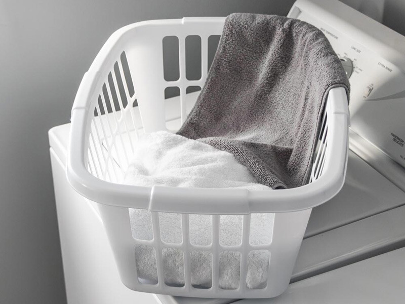 Laundry Solutions: white basket with clean towels sitting atop the washing machine