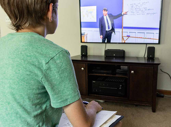 A boy watching a lesson from IEW's Structure and Style for Students