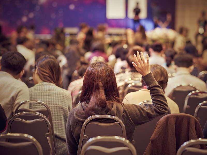 Conference attendee raises hand to ask a question