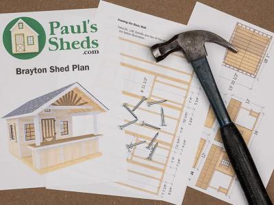 A few pages of the Brayton shed plan from Paul's Sheds splayed out with a hammer and nails